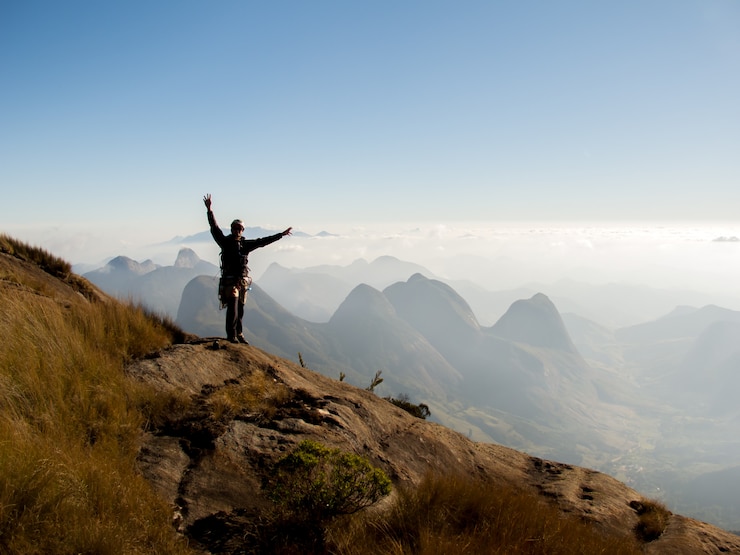 Foto klimmer op de top van een berg na het klimmen