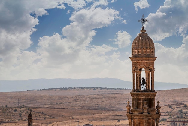 Klokkentoren van de kerk op de achtergrond van de vallei Midyat Turkey