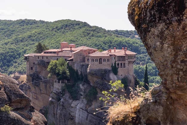 Klooster van st varlaam tegen de achtergrond van dicht beboste heuvels, bedevaart in meteora, griekenland