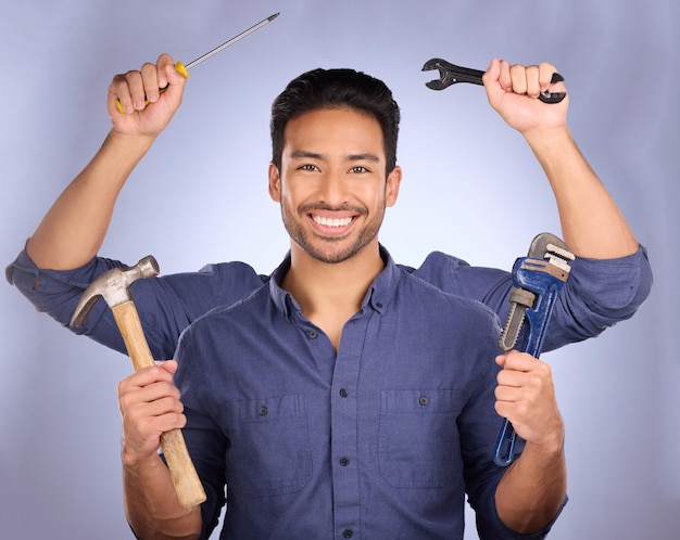 Klusjesman bouwgereedschap en portret van mulitask engineering van een man klaar voor bouwwerkzaamheden Diy huisrenovatieproject en geluk van een model met geïsoleerde studio achtergrond met armen