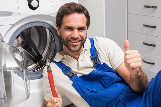 Klusjesman die een wasmachine bevestigt