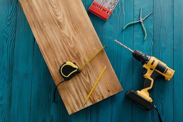 Klusjesman in blauw uniform werkt met elektrische automatische schroevendraaier Huisrenovatieconcept