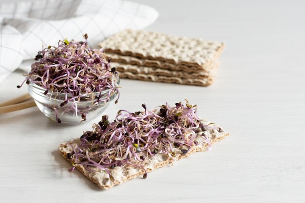 Knäckebröd met rode koolspruiten op witte houten tafel Gekiemde zaden Detox Gezond eten