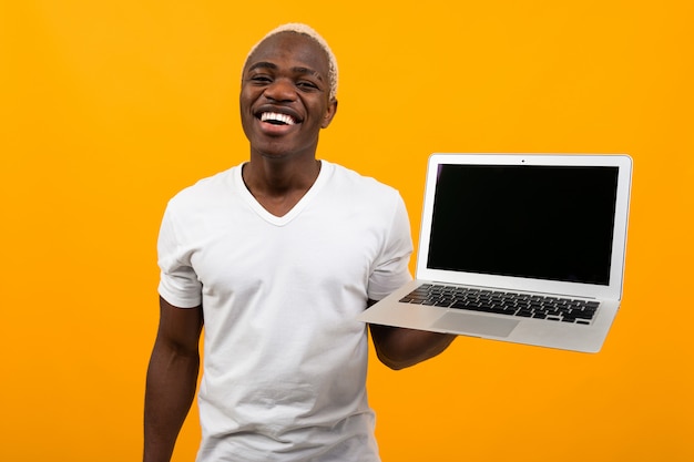 Knappe Afrikaanse laptop van de mensenholding met model op geel
