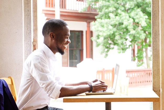 Knappe Afrikaanse zakenman lachend met laptop