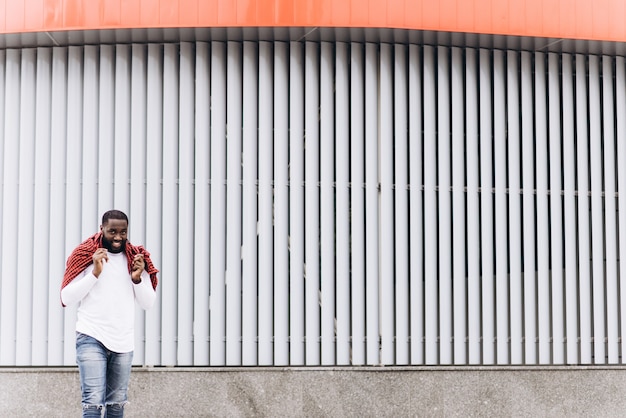 Foto knappe afro-amerikaanse man die casual kleding draagt ​​in de moderne stad