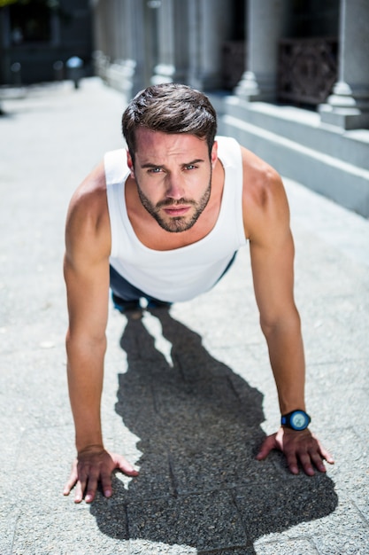 Foto knappe atleet doet push ups