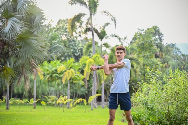 Knappe atletische fitte Aziatische man die zijn armen strekt om op te warmen voor de training