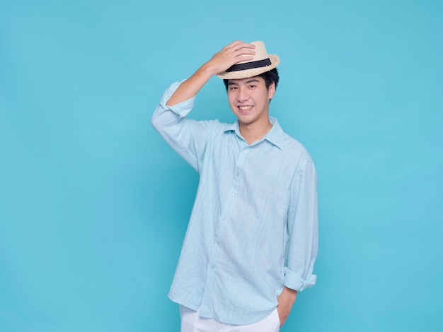 Knappe Aziatische man in een blauw shirt met een hoed