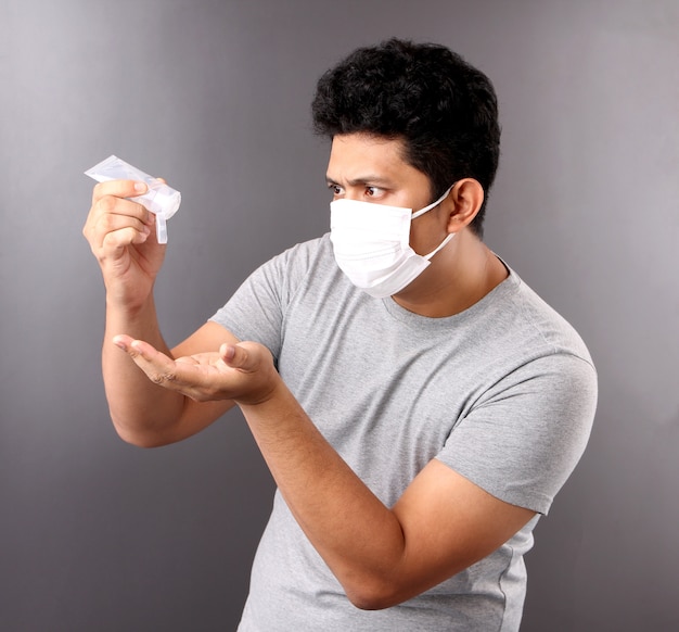 knappe Aziatische man met behulp van alcohol gel en het dragen van een medisch masker, adviseer de preventie van virussen en verschillende ziekten.