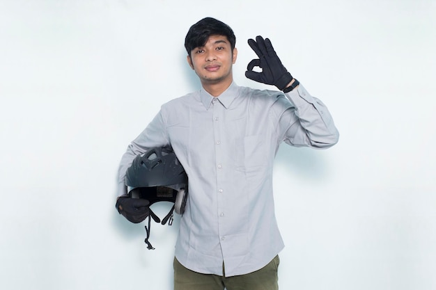 Knappe Aziatische man met een motorhelm met een duim omhoog ok gebaar op witte achtergrond