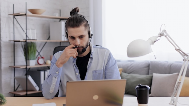 Knappe bebaarde man online studeren met laptop webcamera