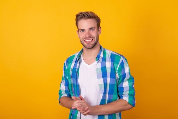 Foto knappe blanke jonge man portret gelukkig lachend in geruit hemd gele achtergrond guy