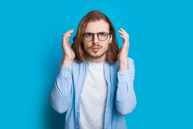 Knappe blanke man met baard en lang haar is ergens door geschokt