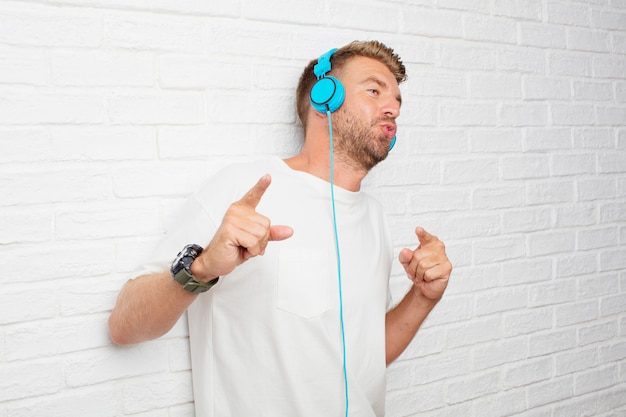 Knappe blondemens het luisteren muziek met hoofdtelefoons