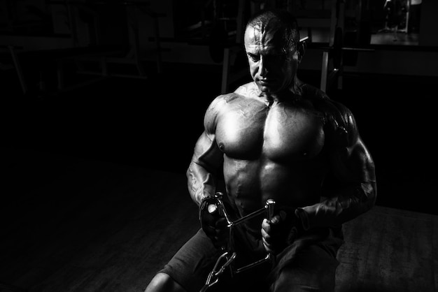 Knappe bodybuilder die zware oefeningen doet om weer op de machine te komen