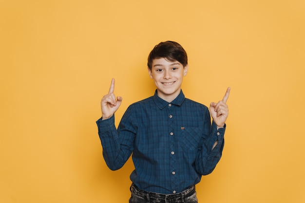 Knappe brunette schooljongen gekleed in casual shirt en spijkerbroek