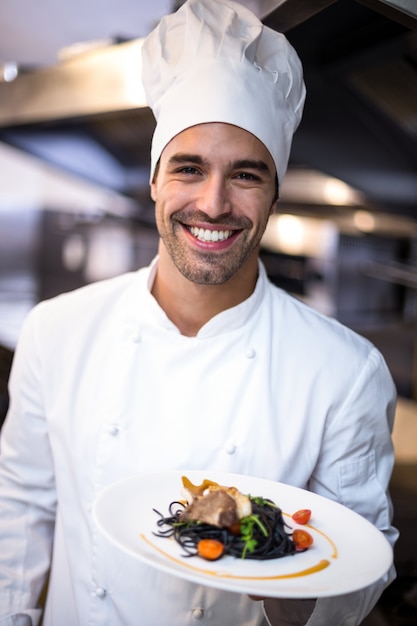 Knappe chef-kok die maaltijd voorstelt