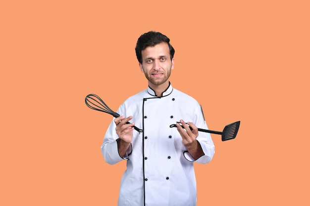 knappe chef-kok kok witte outfit met gereedschap Indiaas Pakistaans model