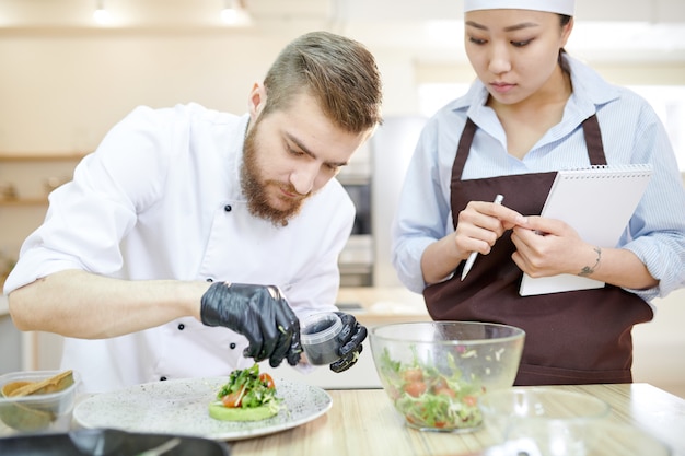 Foto knappe chef-kok plating gerechten