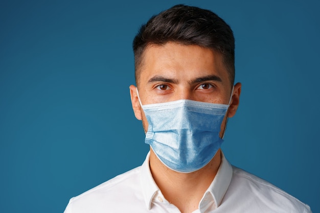 Knappe gemengde rasmens die medisch gezichtsmasker draagt