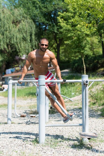 Knappe gespierde jonge man opleiding op de speelplaats In Park