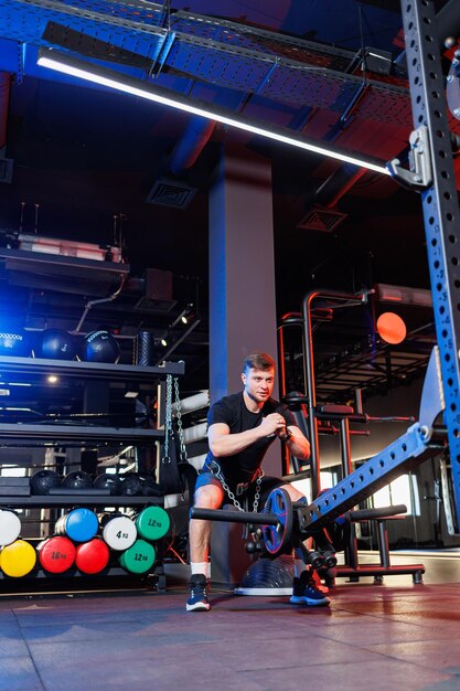 Knappe gespierde man die zware oefeningen doet in de sportschool. Gezonde levensstijl