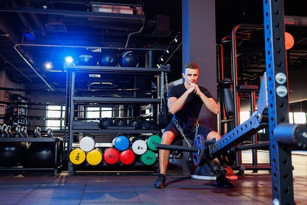 Knappe gespierde man die zware oefeningen doet in de sportschool. Gezonde levensstijl