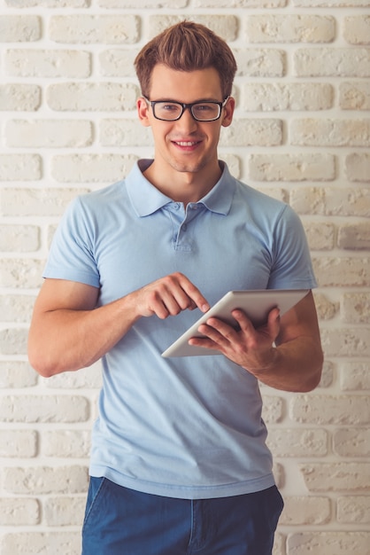 Knappe gespierde man in blauw t-shirt en brillen.