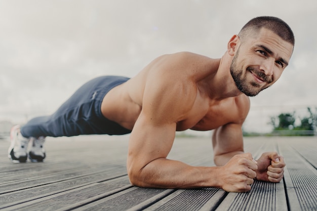 Knappe gespierde man met naakte torso buiten fitnesstraining