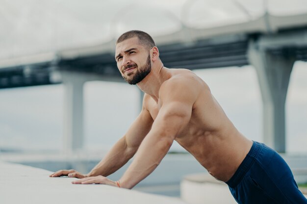 Knappe gespierde man met naakte torso buiten fitnesstraining