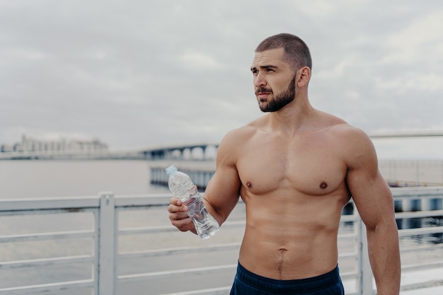 Knappe gespierde man met naakte torso buiten fitnesstraining