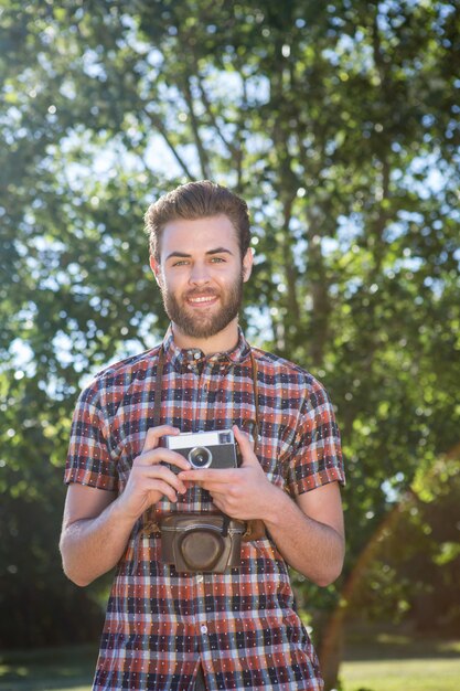 Knappe hipster die uitstekende camera met behulp van