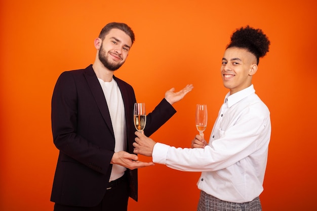 Knappe homo afro-amerikaanse man die een glas wijn aanbiedt aan zijn bebaarde mannelijke vriend