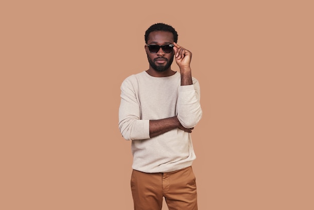 Knappe jonge Afrikaanse man in casual sluiting brillen aanpassen