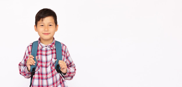 Knappe jonge Aziatische schooljongen met rugzak glimlachend over wit oppervlak smiling