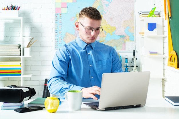 Knappe jonge kerel op lezing aan de universiteit studeren in de klas. Smart onderwijs examen college, middelbare school concept. Student werkt op laptop.