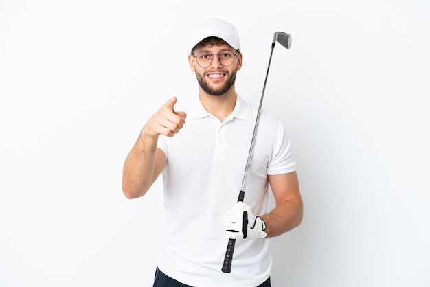 Knappe jonge man golfen geïsoleerd op een witte achtergrond verrast en wijzend naar voren