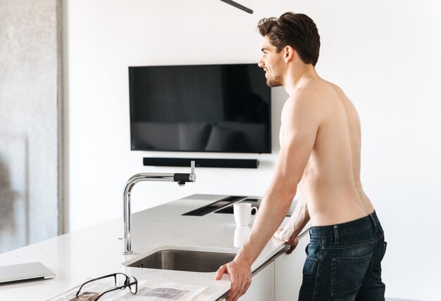 Knappe jonge man in de keuken