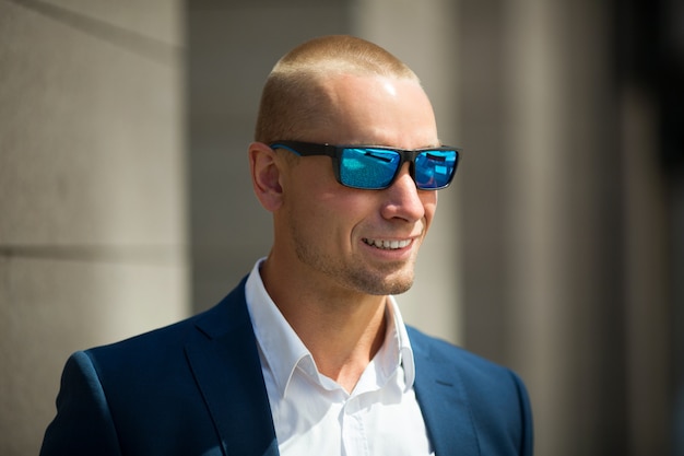 knappe jonge man in een zomer pak op een wandeling in zonnebril