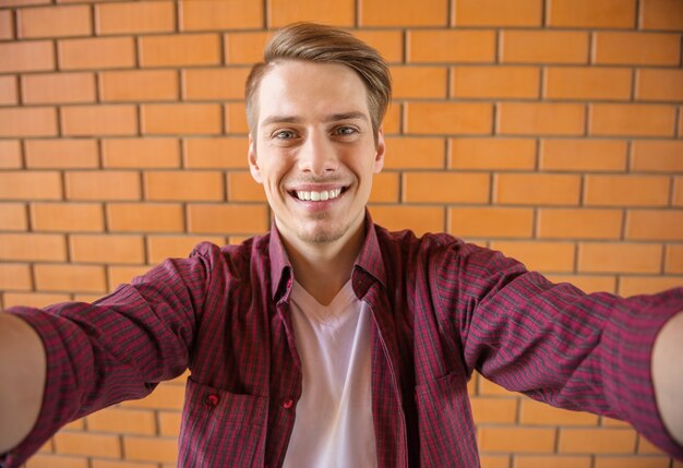 Foto knappe jonge man in slimme vrijetijdskleding selfie maken.