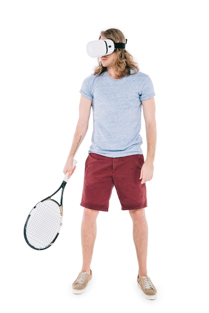 Knappe jonge man in virtual reality headset met tennisracket geïsoleerd op wit