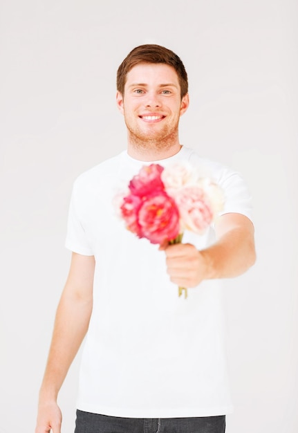 knappe jonge man met boeket bloemen