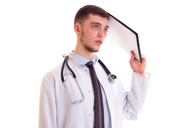 Knappe jonge man met bruin haar in blauwe hemdstropdas en witte doktersjurk met stethoscoop