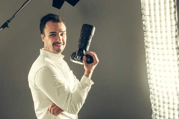 Knappe jonge man met een DSLR-camera.