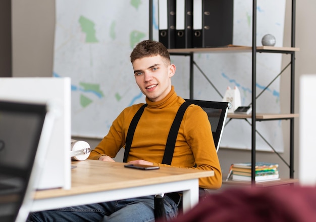 Foto knappe jonge man met koptelefoon zittend in een wit schoon kantoor