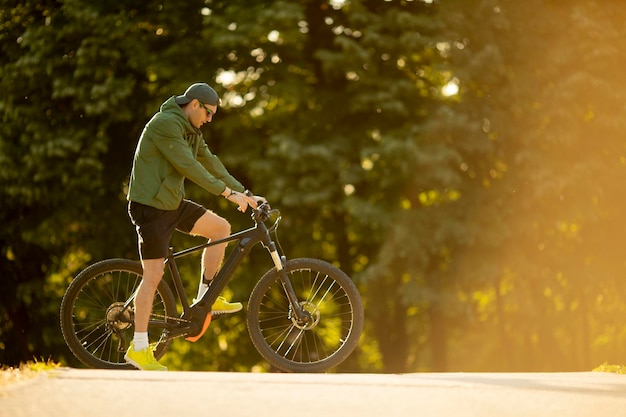 Foto knappe jonge man op ebike rijden in de natuur