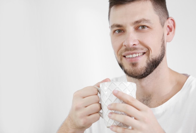 Knappe jonge man thuis koffie drinken close-up