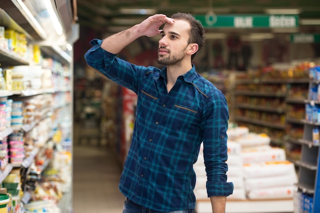 Knappe jonge man winkelen voor groenten en fruit in de productieafdeling van een supermarkt Supermarkt ondiep diep van het veld