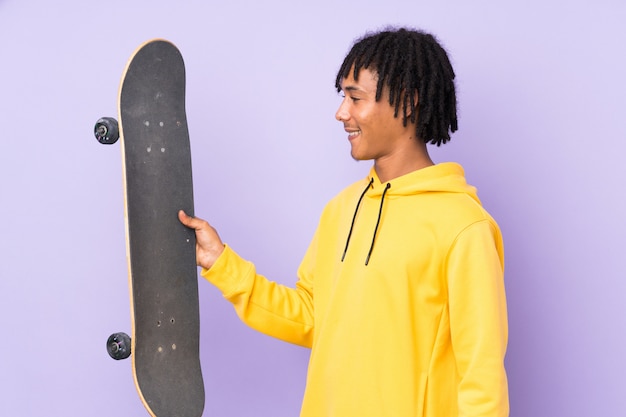 Knappe jonge skater man over geïsoleerde muur met gelukkige uitdrukking